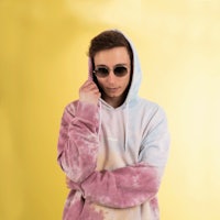 a man wearing a tie dye hoodie and sunglasses